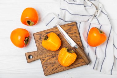 Yapay ahşap arka planda hurma. Hurma meyvesi. Bir parça olgun, sulu, tatlı hurma meyvesi. Vejetaryen. Meyve bahçesi. Yakın plan. Mesaj için yer var. Boşluğu kopyala.