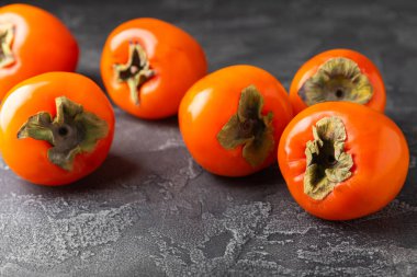 Yapay ahşap arka planda hurma. Hurma meyvesi. Bir parça olgun, sulu, tatlı hurma meyvesi. Vejetaryen. Meyve bahçesi. Yakın plan. Mesaj için yer var. Boşluğu kopyala.