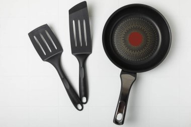 Kızartma tavası. Boş kızartma tavası ve mutfak aletleri ahşap dokulu arka planda. Yemek konsepti. Üst Manzara. Mesaj için yer var. Düz yatıyordu. Tarif.