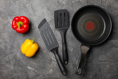 Kızartma tavası. Boş kızartma tavası ve mutfak aletleri ahşap dokulu arka planda. Yemek konsepti. Üst Manzara. Mesaj için yer var. Düz yatıyordu. Tarif.