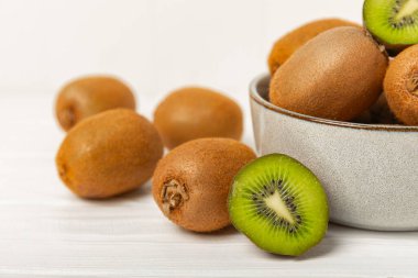 Ahşap arka planda Kivi. Masada tam meyve ve dilimler halinde yeşil kivi var. Taze sulu kivi. Tropik meyve. Organik meyve. Sağlıklı beslenme. Mesaj için yer var. Boşluğu kopyala.