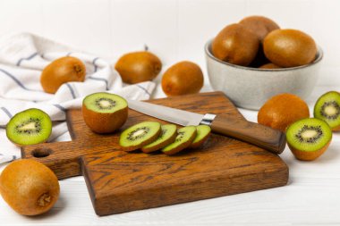 Ahşap arka planda Kivi. Masada tam meyve ve dilimler halinde yeşil kivi var. Taze sulu kivi. Tropik meyve. Organik meyve. Sağlıklı beslenme. Mesaj için yer var. Boşluğu kopyala.