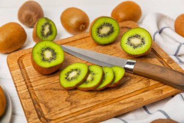 Ahşap arka planda Kivi. Masada tam meyve ve dilimler halinde yeşil kivi var. Taze sulu kivi. Tropik meyve. Organik meyve. Sağlıklı beslenme. Mesaj için yer var. Boşluğu kopyala.