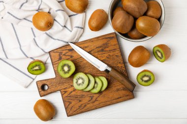 Ahşap arka planda Kivi. Masada tam meyve ve dilimler halinde yeşil kivi var. Taze sulu kivi. Tropik meyve. Organik meyve. Sağlıklı beslenme. Mesaj için yer var. Boşluğu kopyala.