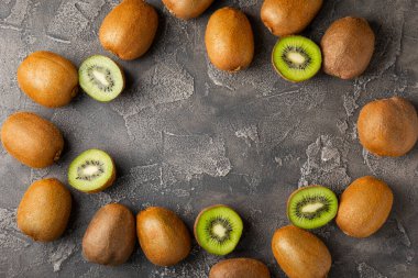 Ahşap arka planda Kivi. Masada tam meyve ve dilimler halinde yeşil kivi var. Taze sulu kivi. Tropik meyve. Organik meyve. Sağlıklı beslenme. Mesaj için yer var. Boşluğu kopyala.