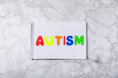 Otizm Farkındalığı Günü .2 Nisan Dünya Otizm Farkındalık Günü arka planı. Temel Tasarım Tasarımı. Renkli ahşap bulmacalar, harfler ve küplerle UTISM metni için dikkat kampanyası.