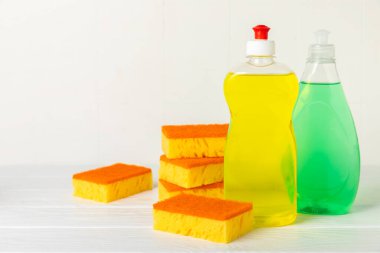 Arka planda renkli bulaşık süngerleri. Mutfak süngeri. Temizlik konsepti, temizlik hizmeti. Bulaşık deterjanı ve temiz ve kirli tabaklar. Metin için yer, kopyalama alanı. Bulaşıkları yıka..