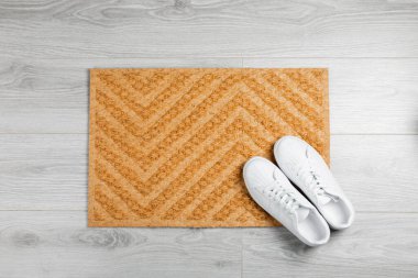 Kapı paspası. Arka planda hoş geldin paspası. Arka plandaki paspasın üzerindeki kadın ayakkabıları. Koridorda iç dekorasyon elemanı var. Yakın plan. Mesaj için yer var. Boşluğu kopyala. Koridordaki kapının yanındaki halı..