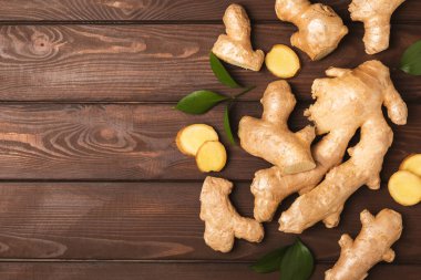 Ahşap arka planda taze zencefil. Kuru zencefil. Ballı ve limonlu zencefil dilimi. Zencefil kökü. Geleneksel alternatif tıp, bağışıklık için çay. Baharat ve baharat konsepti. Boşluğu kopyala.