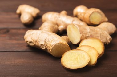 Ahşap arka planda taze zencefil. Kuru zencefil. Ballı ve limonlu zencefil dilimi. Zencefil kökü. Geleneksel alternatif tıp, bağışıklık için çay. Baharat ve baharat konsepti. Boşluğu kopyala.