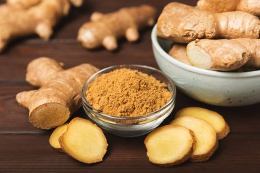 Ahşap arka planda taze zencefil. Kuru zencefil. Ballı ve limonlu zencefil dilimi. Zencefil kökü. Geleneksel alternatif tıp, bağışıklık için çay. Baharat ve baharat konsepti. Boşluğu kopyala.