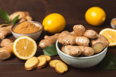 Ahşap arka planda taze zencefil. Kuru zencefil. Ballı ve limonlu zencefil dilimi. Zencefil kökü. Geleneksel alternatif tıp, bağışıklık için çay. Baharat ve baharat konsepti. Boşluğu kopyala.