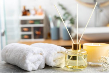 Aromatik kamış oda spreyi ahşap masa üzerinde. Doğal meyveli, çiçekli, baharatlı aromalı yayıcı. İç koku. Ev için lüks parfüm. Portakal, limon, kahve, tarçın, yıldız anason, vanilya ve orkide.