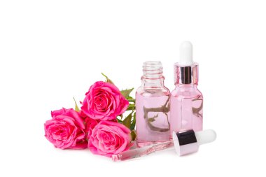 Beyaz arka planda yalıtılmış gül yağı. Güller ve bir şişe gül kokulu su. Aromaterapi tedavisi. Güzellik konsepti. Spa işlemi. Doğal organik yağ. Stres önleyici ve detoks gevşetici..