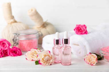 Arka planda gül yağı. Güller ve bir şişe parfümlü su. Romaterapi tedavisi. Güzellik konsepti. Spa prosedürü. Doğal organik yağ. Stres önleyici, detoks gevşetici.
