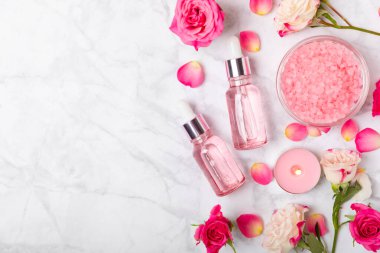 Arka planda gül yağı. Güller ve bir şişe parfümlü su. Romaterapi tedavisi. Güzellik konsepti. Spa prosedürü. Doğal organik yağ. Stres önleyici, detoks gevşetici.