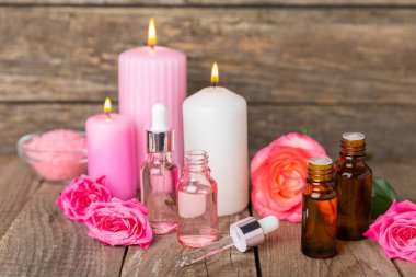 Arka planda gül yağı. Güller ve bir şişe parfümlü su. Romaterapi tedavisi. Güzellik konsepti. Spa prosedürü. Doğal organik yağ. Stres önleyici, detoks gevşetici.