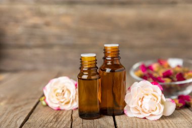 Arka planda gül yağı. Güller ve bir şişe parfümlü su. Romaterapi tedavisi. Güzellik konsepti. Spa prosedürü. Doğal organik yağ. Stres önleyici, detoks gevşetici.