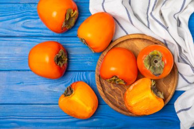 Yapay ahşap arka planda hurma. Hurma meyvesi. Bir parça olgun, sulu, tatlı hurma meyvesi. Vejetaryen. Meyve bahçesi. Yakın plan. Mesaj için yer var. Boşluğu kopyala.