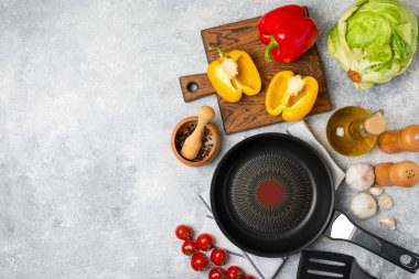 Kızartma tavası. Boş kızartma tavası ve mutfak aletleri ahşap dokulu arka planda. Yemek konsepti. Üst Manzara. Mesaj için yer var. Düz yatıyordu. Tarif.