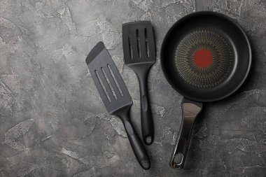 Kızartma tavası. Boş kızartma tavası ve mutfak aletleri ahşap dokulu arka planda. Yemek konsepti. Üst Manzara. Mesaj için yer var. Düz yatıyordu. Tarif.