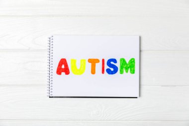 Otizm Farkındalığı Günü .2 Nisan Dünya Otizm Farkındalık Günü arka planı. Temel Tasarım Tasarımı. Renkli ahşap bulmacalar, harfler ve küplerle UTISM metni için dikkat kampanyası.
