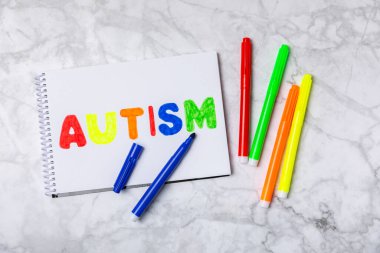 Otizm Farkındalığı Günü .2 Nisan Dünya Otizm Farkındalık Günü arka planı. Temel Tasarım Tasarımı. Renkli ahşap bulmacalar, harfler ve küplerle UTISM metni için dikkat kampanyası.