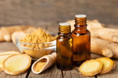 Doku arka planında zencefil yağı var. Taze zencefil dilimleri. Esans, serum, yağ. Alternatif tıp. Beden eğitimi. Sağlık ve güzellik konsepti. Mesaj için yer. Boşluğu kopyala.