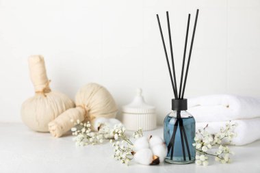 Aromatik kamış oda spreyi ahşap masa üzerinde. Doğal meyveli, çiçekli, baharatlı aromalı yayıcı. İç koku. Ev için lüks parfüm. Portakal, limon, kahve, tarçın, yıldız anason, vanilya ve orkide.