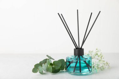 Aromatik kamış oda spreyi ahşap masa üzerinde. Doğal meyveli, çiçekli, baharatlı aromalı yayıcı. İç koku. Ev için lüks parfüm. Portakal, limon, kahve, tarçın, yıldız anason, vanilya ve orkide.