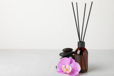 Aromatik kamış oda spreyi ahşap masa üzerinde. Doğal meyveli, çiçekli, baharatlı aromalı yayıcı. İç koku. Ev için lüks parfüm. Portakal, limon, kahve, tarçın, yıldız anason, vanilya ve orkide.