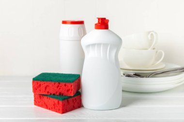 Arka planda renkli bulaşık süngerleri. Mutfak süngeri. Temizlik konsepti, temizlik hizmeti. Bulaşık deterjanı ve temiz ve kirli tabaklar. Metin için yer, kopyalama alanı. Bulaşıkları yıka..
