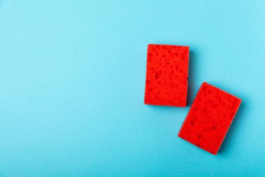 Arka planda renkli bulaşık süngerleri. Mutfak süngeri. Temizlik konsepti, temizlik hizmeti. Bulaşık deterjanı ve temiz ve kirli tabaklar. Metin için yer, kopyalama alanı. Bulaşıkları yıka..