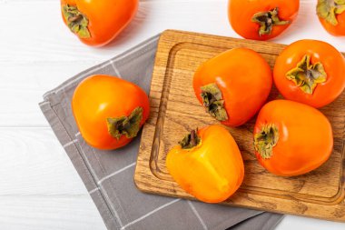 Yapay ahşap arka planda hurma. Hurma meyvesi. Bir parça olgun, sulu, tatlı hurma meyvesi. Vejetaryen. Meyve bahçesi. Yakın plan. Mesaj için yer var. Boşluğu kopyala.