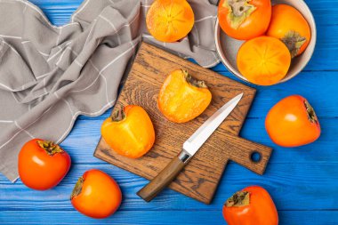 Yapay ahşap arka planda hurma. Hurma meyvesi. Bir parça olgun, sulu, tatlı hurma meyvesi. Vejetaryen. Meyve bahçesi. Yakın plan. Mesaj için yer var. Boşluğu kopyala.