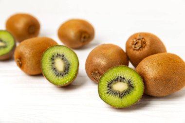 Ahşap arka planda Kivi. Masada tam meyve ve dilimler halinde yeşil kivi var. Taze sulu kivi. Tropik meyve. Organik meyve. Sağlıklı beslenme. Mesaj için yer var. Boşluğu kopyala.