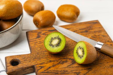 Ahşap arka planda Kivi. Masada tam meyve ve dilimler halinde yeşil kivi var. Taze sulu kivi. Tropik meyve. Organik meyve. Sağlıklı beslenme. Mesaj için yer var. Boşluğu kopyala.