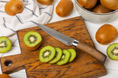 Ahşap arka planda Kivi. Masada tam meyve ve dilimler halinde yeşil kivi var. Taze sulu kivi. Tropik meyve. Organik meyve. Sağlıklı beslenme. Mesaj için yer var. Boşluğu kopyala.