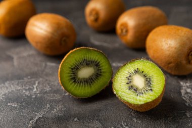 Ahşap arka planda Kivi. Masada tam meyve ve dilimler halinde yeşil kivi var. Taze sulu kivi. Tropik meyve. Organik meyve. Sağlıklı beslenme. Mesaj için yer var. Boşluğu kopyala.