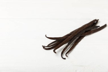 Dokulu bir arka planda vanilya kabukları. Vanilya çiçekleri ve tohumlar. Vanilyalı fasulye. Hamur işleri ve tatlılar için baharatlı baharat. Baharat. Mesaj için yer var. Boşluğu Kopyala