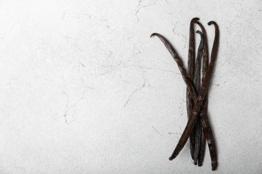 Dokulu bir arka planda vanilya kabukları. Vanilya çiçekleri ve tohumlar. Vanilyalı fasulye. Hamur işleri ve tatlılar için baharatlı baharat. Baharat. Mesaj için yer var. Boşluğu Kopyala