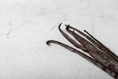 Dokulu bir arka planda vanilya kabukları. Vanilya çiçekleri ve tohumlar. Vanilyalı fasulye. Hamur işleri ve tatlılar için baharatlı baharat. Baharat. Mesaj için yer var. Boşluğu Kopyala