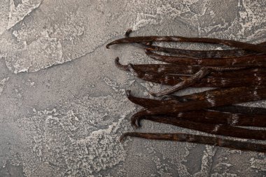 Dokulu bir arka planda vanilya kabukları. Vanilya çiçekleri ve tohumlar. Vanilyalı fasulye. Hamur işleri ve tatlılar için baharatlı baharat. Baharat. Mesaj için yer var. Boşluğu Kopyala