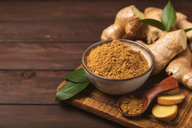 Ahşap arka planda taze zencefil. Kuru zencefil. Ballı ve limonlu zencefil dilimi. Zencefil kökü. Geleneksel alternatif tıp, bağışıklık için çay. Baharat ve baharat konsepti. Boşluğu kopyala.