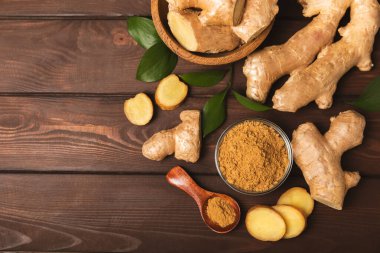 Ahşap arka planda taze zencefil. Kuru zencefil. Ballı ve limonlu zencefil dilimi. Zencefil kökü. Geleneksel alternatif tıp, bağışıklık için çay. Baharat ve baharat konsepti. Boşluğu kopyala.