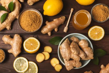 Ahşap arka planda taze zencefil. Kuru zencefil. Ballı ve limonlu zencefil dilimi. Zencefil kökü. Geleneksel alternatif tıp, bağışıklık için çay. Baharat ve baharat konsepti. Boşluğu kopyala.