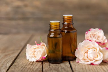 Arka planda gül yağı. Güller ve bir şişe parfümlü su. Romaterapi tedavisi. Güzellik konsepti. Spa prosedürü. Doğal organik yağ. Stres önleyici, detoks gevşetici.