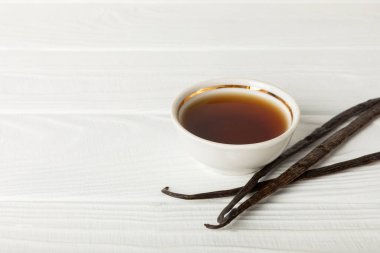 Tahta bir masanın üzerinde cam kaplama vanilya özü. Kek ve tatlı için vanilya özü. Aromatik ev yapımı vanilya özü. Kapatın. Mesajı yerleştir. Boşluğu kopyala.