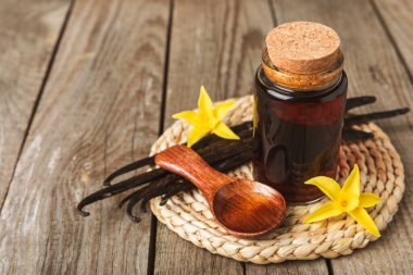 Tahta bir masanın üzerinde cam kaplama vanilya özü. Kek ve tatlı için vanilya özü. Aromatik ev yapımı vanilya özü. Kapatın. Mesajı yerleştir. Boşluğu kopyala.