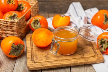 Tahta desenli masada olgun hurma dilimleriyle hurma reçeli. Lezzetli hurma reçeli. Marmelat. Sağlıklı tatlılar. Vejetaryen. Yakın plan. Mesaj için yer var. Boşluğu kopyala.